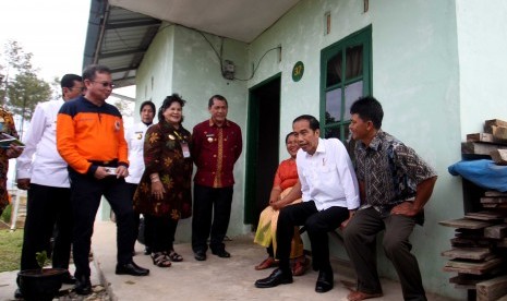 Presiden Joko Widodo (tengah) bersama Kepala BNPB Willem Rampangilei (kiri) dan Bupati Karo Terkelin Brahmana (kiri ketiga) berbincang dengan warga saat berkunjung di kawasan perumahan relokasi pengungsi Gunung Sinabung di Desa Siosar, Karo, Sumatra Utara, Sabtu (14/10). 