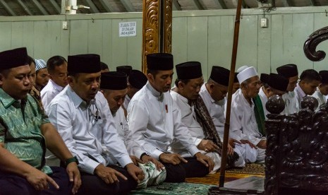 Presiden Joko Widodo (tengah) bersama pengasuh Pondok Pesantren Girikesumo, KH Munif Zuhri (kelima kiri) menunaikan salat Magrib berjamaah saat mengunjungi pesantren tersebut di Desa Banyumeneng, Mranggen, Demak, Jawa Tengah, Jumat (19/10/2018). 