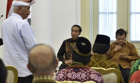 Presiden Joko Widodo (tengah) bersama Wakil Presiden Jusuf Kalla (kanan) mendengarkan laporan Ketua Umum Asosiasi Forum Kerukunan Umat Beragama Ida Penglingsir Agung Putra Sukahet (kiri) saat pertemuan di Istana Bogor, Jawa Barat, Selasa (23/5).