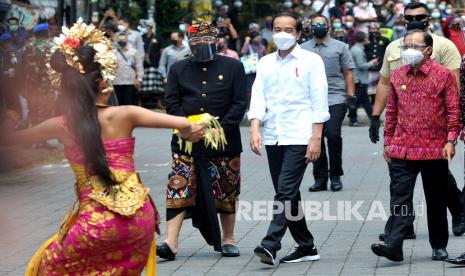 Presiden Joko Widodo (tengah) didampingi Gubernur Bali Wayan Koster (kanan) dan Wagub Bali Tjokorda Oka Artha Ardana Sukawati (kiri) disambut penari Bali saat akan meninjau proses vaksinasi COVID-19 di Puri Ubud, Gianyar, Bali, Selasa (16/3/2021). Kunjungan tersebut dilakukan Presiden Jokowi untuk melihat secara langsung proses vaksinasi secara massal kepada para pelayan publik, tokoh agama dan adat serta masyarakat setempat.