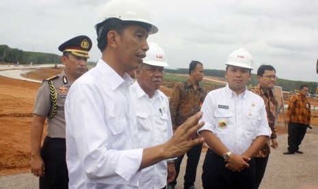 Presiden Joko Widodo (tengah) didampingi Gubernur Lampung M Ridho Ficardo (kanan) melakukan kunjungan ke lokasi pembangunan Tol Trans Sumatera, Lampung, Kamis (11/2).