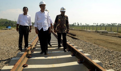 Presiden Joko Widodo (tengah) didampingi Gubernur Sulawesi Selatan Syahrul Yasin Limpo (kanan), meninjau pembangunan jalur kereta api Trans Sulawesi di Desa Telumpanua, Kecamatan Tanete Riau, Kabupaten Barru, Sulawesi Selatan, Rabu (25/11). 