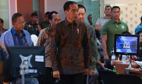 Presiden Joko Widodo (tengah) didampingi Menko Perekonomian Darmin Nasution (kiri) dan Kepala BKPM Thomas Lembong (kedua kanan) meninjau layanan konsultasi Online Single Submission (OSS) BKPM di PTSP BKPM Jakarta, Senin (14/1/2019). 