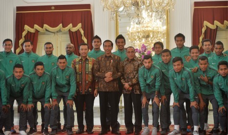 Presiden Joko Widodo (tengah) didampingi Menpora Imam Nahrawi (kelima kiri) serta Ketua PSSI Edy Rahmayadi (kelima kanan) berfoto bersama Tim Nasional Sepakbola Indonesia Piala AFF di Istana Merdeka, Jakarta, Senin (19/12). 