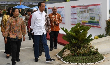 Presiden Joko Widodo (tengah) didampingi Menteri BUMN Rini Soemarno (kiri) mengamati peta tol saat meresmikan Tol Solo-Ngawi segmen Sragen-Ngawi di Rest Area KM 538, Sragen, Jawa Tengah, Rabu (28/11/2018).