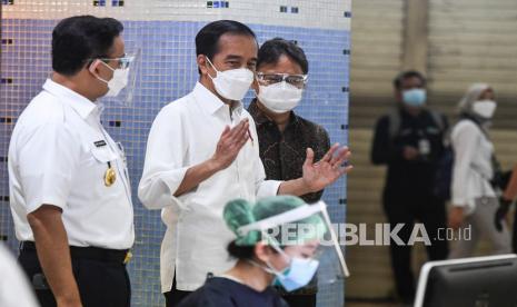 Presiden Joko Widodo (tengah) didampingi Menteri Kesehatan Budi Gunadi Sadikin (kanan) berbincang dengan Gubernur DKI Jakarta Anies Baswedan saat meninjau vaksinasi COVID-19 massal bagi pedagang di Pasar Tanah Abang Blok A, Jakarta, Rabu (17/2/2021). Vaksinasi COVID-19 tahap kedua yang diberikan untuk pekerja publik dan lansia itu dimulai dari pedagang Pasar Tanah Abang. 