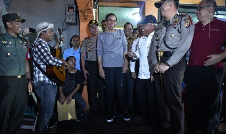 Presiden Joko Widodo (tengah) didampingi Menteri Pekerjaan Umum dan Perumahan Rakyat Basuki Hadimuljono (ketiga kanan) dan Menteri Perhubungan Budi Karya Sumadi (keempat kanan) bernyanyi usai makan malam di Sate Kambing Haji Mamat, Sukabumi, Jawa Barat, Sabtu (7/4). Kunjungan kerja Presiden ke Sukabumi diantaranya untuk meninjau pelaksanaan program padat karya dan penyerahan sertifikat tanah untuk warga.