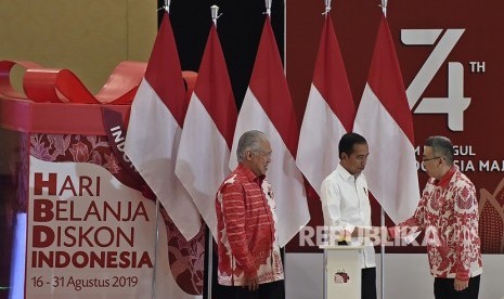 Presiden Joko Widodo (tengah) didampingi Menteri Perdagangan Enggartiasto Lukita (kiri) menjabat tangan Ketua Umum Himpunan Penyewa Pusat Perbelanjaan Indonesia (Hippindo) Budiharjo Iduansjah usai membuka Hari Belanja Diskon (HBD) Indonesia 2019 di The Hall Senayan City, Jakarta, Kamis (15/8/2019). 