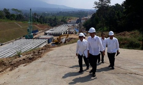 Presiden Joko Widodo (tengah) didampingi Menteri PUPR Basuki Hadimuljono (kanan) meninjau pembangunan jalan tol Bocimi seksi satu, Rabu (21/6).