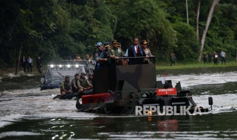  Presiden Joko Widodo (tengah) didampingi Panglima TNI Gatot Nurmantyo (kiri) dan Kapolri Tito Karnavian menyusuri danau menggunakan Panser Anoa 2 6x6 Amphibious sebelum Rapat Pimpinan TNI di Mabes TNI, Cilangkap, Jakarta, Senin (16/1).