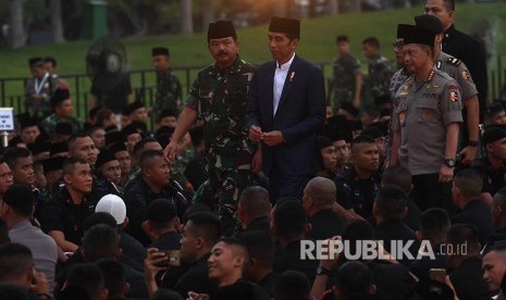 Presiden Joko Widodo (tengah) didampingi Panglima TNI Marsekal TNI Hadi Tjahjanto (kiri) dan Kapolri Jenderal Pol Tito Karnavian (kanan) tiba di lokasi acara buka puasa bersama keluarga besar TNI-Polri dan masyarakat di Jakarta, Kamis (16/5)