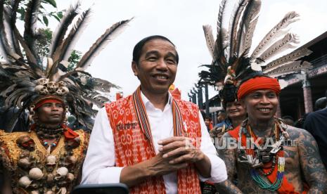 Presiden Joko Widodo (tengah) didampingi Pemimpin Pasukan Merah Tariu Borneo Bangkule Rajakng (TBBR) Panglima Jilah (kanan) usai menghadiri acara temu akbar Pasukan Merah BBR di Rumah Radakng, Pontianak, Kalimantan Barat, Selasa (29/11/2022).