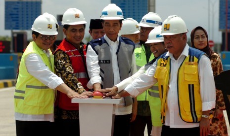 Presiden Joko Widodo (tengah) didampingi Sekretaris Kabinet Kerja Pramono Anung (kiri), Menteri PUPR Basuki Hadimuljono (kanan), Menteri BUMN Rini Soemarno (kedua kanan) dan Wakil Gubernur Jawa Tengah Taj Yasin (kedua kiri) menekan tombol saat peresmian tol Pejagan-Pemalang, di Gate Tol Tegal, Kalimati, Kabupaten Tegal, Jawa Tengah, Jumat (9/11/2018).