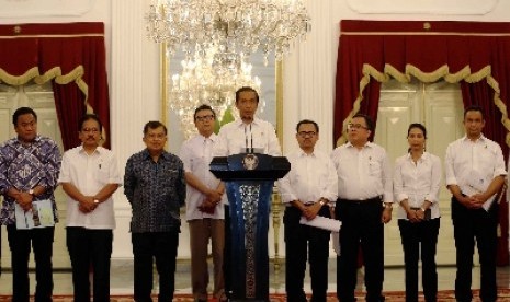 Presiden Joko Widodo (tengah) didampingi Wapres Jusuf Kalla (keempat kiri) dan para Menteri Kabinet Kerja mengumumkan kenaikan harga BBM bersubsidi di Istana Merdeka, Jakarta, Senin (17/11) malam.