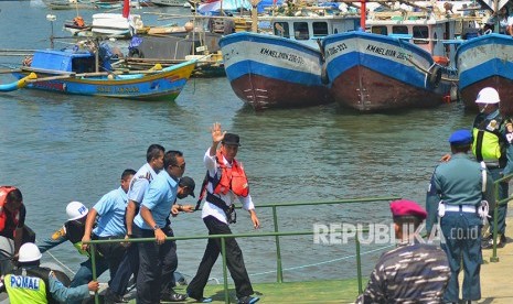 Presiden Joko Widodo (tengah) melambaikan tangan kepada warga seusai meninjau keramba ikan saat peresmian Keramba Jaring Apung atau offshore di Pelabuhan Pendaratan Ikan (PPI) Cikidang, Babakan, Kabupaten Pangandaran, Jawa Barat, Selasa (24/4). 