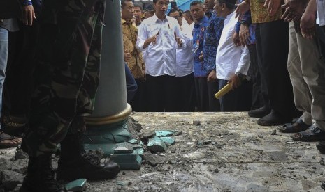 Presiden Joko Widodo (tengah) melihat kondisi bangunan Masjid Atta Darut yang rusa berat di Pidie Jaya, Aceh, Jumat (9/12).