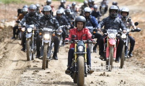 Presiden Joko Widodo (tengah) melintasi jalan Trans Kalimantan di Kecamatan Krayan, Kabupaten Nunukan, Kalimantan Utara, Kamis (19/12/2019). 