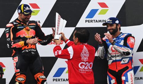 Presiden Joko Widodo (tengah) memberikan trofi juara pertama kepada pembalap Red Bull KTM Factory Racing Miguel Oliveira (kiri) disaksikan juara ketiga Johann Zarco di podium seusai balapan MotoGP seri Pertamina Grand Prix of Indonesia di Pertamina Mandalika International Street Circuit, Lombok Tengah, NTB, Ahad (20/3/2022). Menteri Badan Usaha Milik Negara (BUMN) Erick Thohir bersyukur dengan kesuksesan penyelenggaraan MotoGP 2022 Seri Pertamina Grand Prix of Indonesia di Mandalika, Lombok Tengah, Nusa Tenggara Barat (NTB), pada 18 Maret hingga 20 Maret 2022. Erick menyebut ajang MotoGP Mandalika terasa amat istimewa lantaran terakhir kali Indonesia menjadi tuan rumah pada 25 tahun silam di Sentul, Jawa Barat.