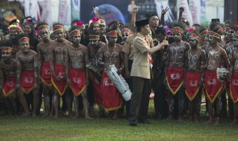 Presiden Joko Widodo (tengah) mengacungkan jempol usai berfoto bersama para anggota pramuka berkostum tradisional Papua dalam acara Raimuna Nasional XI yang bertepatan dengan peringatan ulang tahun Pramuka ke-56 di, Bumi Perkemahan Cibubur, Jakarta, Senin (14/8). 