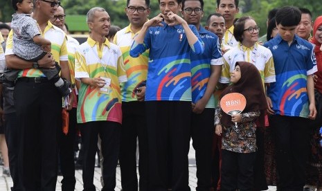 Presiden Joko Widodo (tengah) didampingi Ketua PPDI Gufroni Sakaril saat menghadiri Peringatan Hari Disabilitas Internasional Tahun 2018 di Bekasi, Jawa Barat, Senin (3/12/2018). 