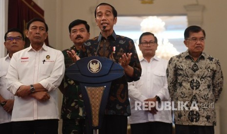 Presiden Joko Widodo (tengah) menyampaikan keterangan terkait kerusuhan pascapengumunan hasil pemilu 2019 di Istana Merdeka, Jakarta, Rabu (22/5/2019). 