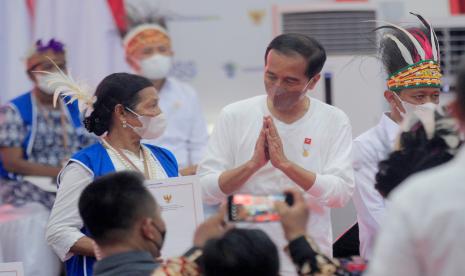 Presiden Joko Widodo (tengah) menyapa warga saat penyerahan Nomor Induk Berusaha (NIB) bagi pelaku usaha mikro kecil menengah (UMKM) perseorangan di Gedung Olah Raga (GOR) Toware, Distrik Waibu, Sentani, Jayapura, Papua. Direktorat Informasi dan Komunikasi Perekonomian dan Maritim, Kementerian Komunikasi dan Informatika mendukung melalui Gerakan Pendaftaran 1.500 Nomor Induk Berusaha secara Online & Serentak.