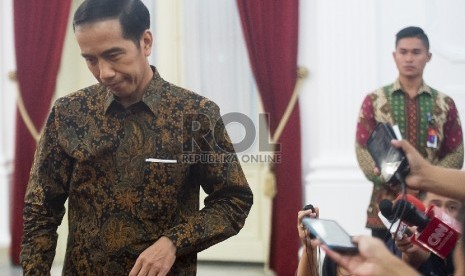   Presiden Joko Widodo usai menjawab pertanyaan wartawna terkait papa minta saham Freeport di Istana Merdeka, Senin (7/12).