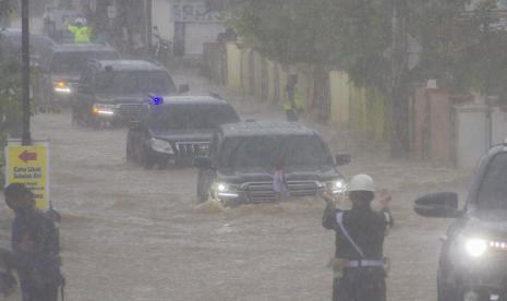 Presiden Joko Widodo yang berada di dalam mobil kepresidenan melintasi banjir di Desa Pekauman Ulu, Kabupaten banjar, Kalimantan Selatan, Senin (18/1).