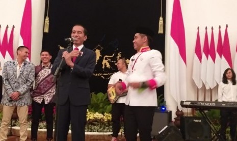 Presiden Jokowi dan anggota paduan suara Gita Bahana Nusantara asal Sulawesi Selatan, Abel Romario P di Istana Negara, Sabtu (17/8). 