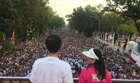 Presiden Jokowi dan Ibu Negara Iriana menyapa peserta jalan sehat yang diprakarsai Sahabat Rakyat Indonesia di Makassar,Sulawesi Selatan, Ahad (29/7) pagi.