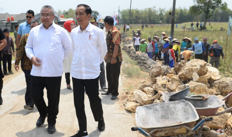 Presiden Jokowi dan Mendes PDTT Eko Putro Sandjojo meninjau Padat Karya Tunai (PKT) pembangunan talud jalan di Desa Tambirejo, Kecamatan Toroh, Kabupaten Grobogan, Jawa Tengah.