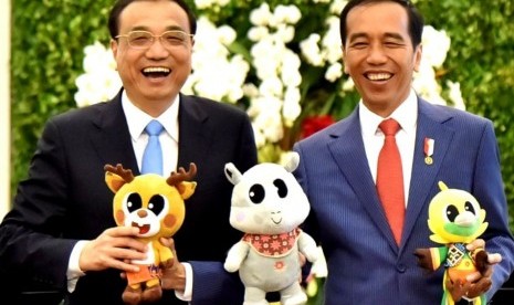 Presiden Jokowi dan PM Cina Li Keqiang berfoto bersama sambil menunjukkan maskot Asian Games di Istana Bogor, Senin (7/5). 