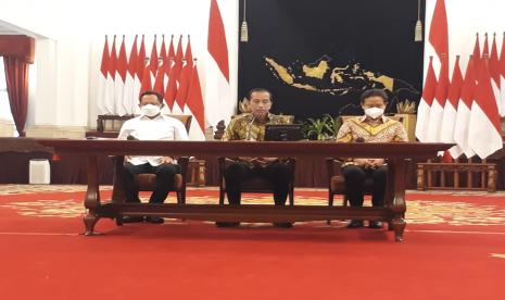 Presiden Jokowi didampingi Menkes Budi Gunadi Sadikin dan Mendagri Tito Karnavian, mengumumkan pencabutan kebijakan PPKM di Istana Negara, Jakarta, Jumat (30/12). 