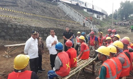 Presiden Jokowi didampingi Menteri Perhubungan Budi Karya, Menteri PUPR Basuki Hadimuldjono, dan Kepala KSP Moeldoko meninjau program padat karya tunai jalur gandra KA Bogor-Sukabumi di Desa Tenjoayu,  Sabtu (7/4).