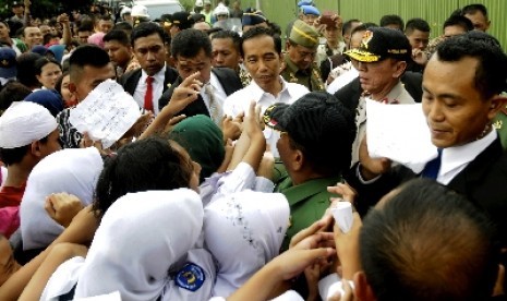 Presiden Jokowi disambut siswa SD di sentra rajut Binong Jati, Bandung, Senin (12/1).