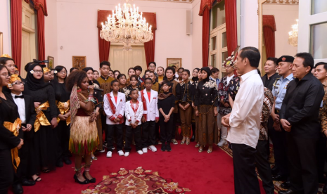 Presiden Jokowi mendengarkan lantunan Indonesia Pusaka yang dinyanyikan Vien Reyes, penyanyi asal Papua.  