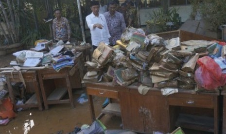 Presiden Jokowi meninjau aset pustaka sekolah yang rusak dampak banjir bandang di SMPN 1 Arjosari, Pacitan, Jawa Timur, Sabtu (9/12). Presiden memastikan proses pemulihan infrastruktur yang rusak, rehabilitasi rumah terdampak bencana hingga penyediaan aset pendidikan di 89 sekolah yang hilang/hanyut terendam banjir-longsor tuntas sebelum akhir Desember 2017, sehingga aktivitas warga, perekonomian serta dunia pendidikan kembali normal. 