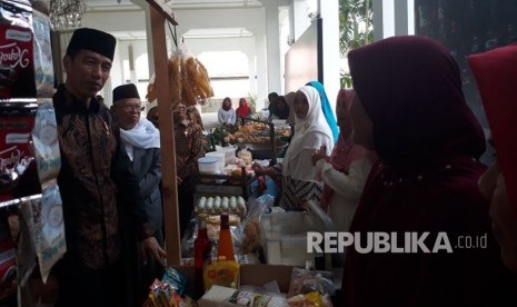 Presiden Jokowi meninjau pameran pedagang yang ikut dalam program bank wakaf mikro di Istana Negara, Rabu (28/3). 