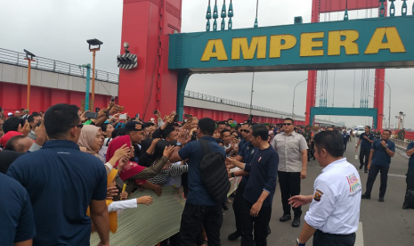 Presiden Jokowi menyapa warga yang memadati Jembatan Ampera Palembang dalam acara Millennial Road Safety Festival, Sabtu (9/3). 