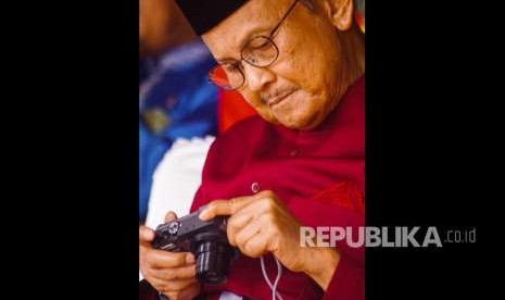 Presiden ke-3 Republik Indonesia B.J. Habibie melihat hasil foto di kamera digitalnya saat menghadiri Peringatan HUT ke-61 Provinsi Riau di Kota Pekanbaru, Kamis (9/8).