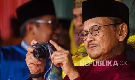 Presiden ke-3 Republik Indonesia B.J. Habibie memotret dengan kamera digital saat menghadiri Peringatan HUT ke-61 Provinsi Riau di Kota Pekanbaru, Kamis (9/8).