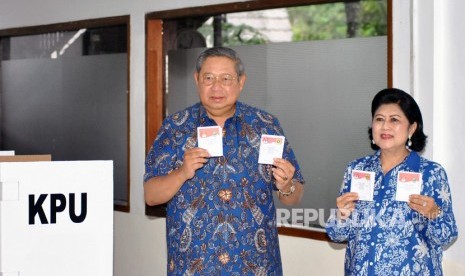 Presiden ke-6 RI sekaligus Ketua Umum Partai Demokrat Susilo Bambang Yudhoyono (kiri) bersama istri Ani Yudhoyono, menunjukkan surat suara saat menggunakan hak pilih di TPS 06, Sekolah Alam Cikeas, Nagrak, Gunung Putri, Kabupaten Bogor, Jawa Barat, Rabu (27/6)