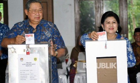 Presiden ke-6 RI sekaligus Ketua Umum Partai Demokrat Susilo Bambang Yudhoyono (kiri) bersama istri Ani Yudhoyono, memasukkan surat suara ke dalam kotak saat menggunakan hak pilih di TPS 06, Sekolah Alam Cikeas, Nagrak, Gunung Putri, Kabupaten Bogor, Jawa Barat, Rabu (27/6).