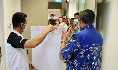 Presiden keenam RI Susilo Bambang Yudhoyono (SBY) ketika memeriksa surat suara yang akan digunakan oleh istrinya, Ani Yudhoyono. Ibu Ani yang sedang menjalani perawatan menggunakan hak pilihnya di National Universitity Hospital Singapura, Ahad (14/4).