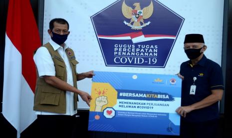 Presiden Komisaris Independen Bentoel Group Hendro Martowardojo (kanan) menyerahkan bantuan alat pelindung diri (APD) dengan jumlah total 3.600 buah, masker sebanyak 22 ribu lembar, kaca mata pelindung sebanyak 1.200 buah, sarung tangan medis sebanyak 5.850 pasang, serta hand sanitizer dengan jumlah total 10 ribu liter. Bantuan tersebut telah diserahkan langsung kepada Kepala Badan Nasional Penanggulangan Bencana (BNPB) yang juga Kepala Gugus Tugas Penanganan Covid-19, Doni Monardo, di Graha BNPB, di Jakarta.