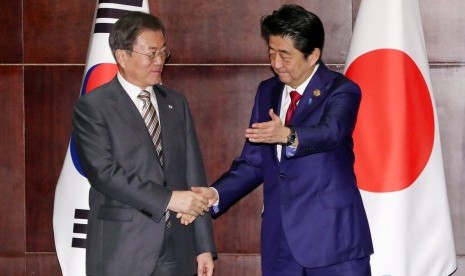 Jepang dan Korsel Cari Jalan Keluar Perselisihan. Presiden Korea Selatan (Korsel) Moon Jae-in (kiri) bersalaman dengan Perdana Menteri Jepang Shinzo Abe di Chengdu, China, Selasa (24/12).