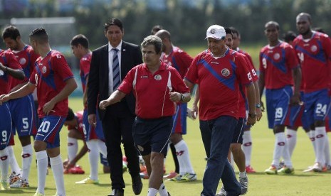 Presiden Kosta Rika, Luis Guillermo Solis (kanan), berjalan bersama pelatih timnas Jorge Luin Pinto dan pemain timnas di San Antonio de Belen, San Jose, Jumat (30/5). 