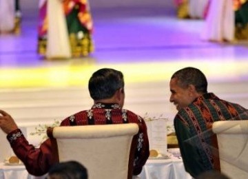 Presiden mengenakan kemeja berbahan kain tenun ikat merahmerah sedang berbincang dengan Presiden AS yang mengenakan kemeja tenun ikat hijau pada jamuan makan malam kenegaraan