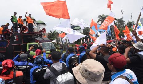 Presiden Partai Buruh Said Iqbal (kiri) menyampaikan orasinya saat unjuk rasa bersama buruh di depan Gedung DPR, Jakarta, Jumat (11/3/2022). Dalam aksinya mereka menolak penundaan Pemilu 2024, menuntut pencabutan Permenaker Nomor 2 Tahun 2022 tentang Jaminan Hari Tua (JHT), menolak omnibus law UU Cipta Kerja serta meminta pemerintah menurunkan harga bahan pokok.