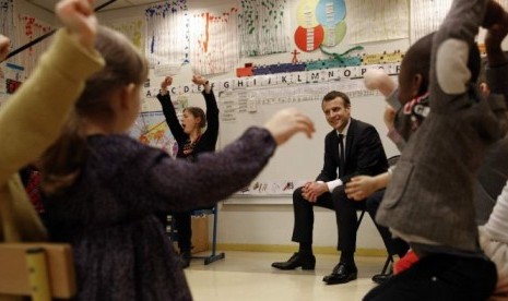 Presiden Perancis Emmanuel Macron ketika mengunjungi anak-anak usia dini di Paris.  